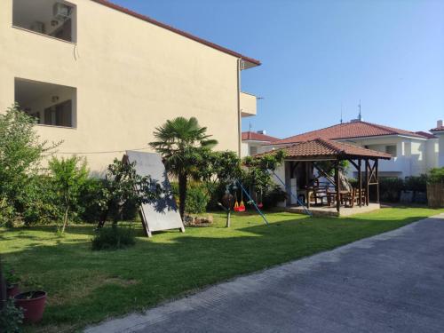 a yard next to a house with a playground at Polynikis Apartment in Nikiti
