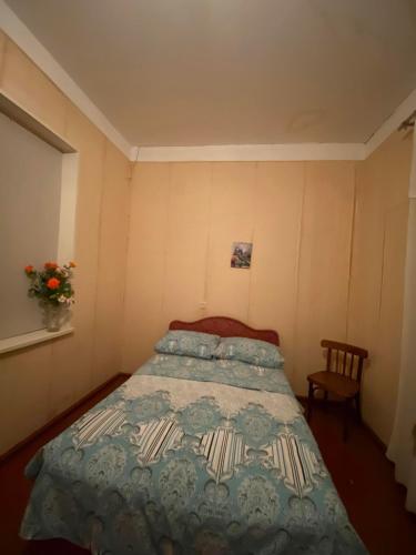 a bedroom with a bed with a quilt on it at Guest House Shateau in Sagarejo
