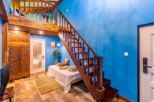 a staircase in a room with blue walls at Beijing Shixi Inn - Wangfujing Nanluoguxiang Branch in Beijing