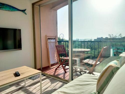 a living room with a view of a balcony at Ambeille Collioure in Collioure