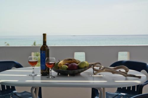 a table with a bowl of fruit and a bottle of wine at Paradise Studios in Agiassos