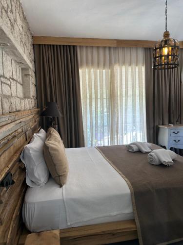 um quarto com uma cama grande em frente a uma janela em Argente Alaçatı (Adult Only) em Alacati