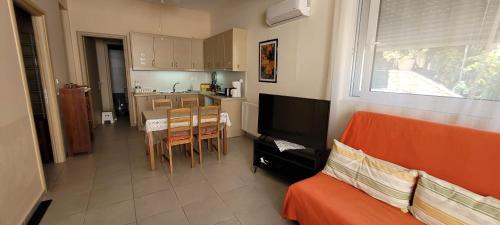 a living room with a couch and a table and a kitchen at Family Apartment in Derveni