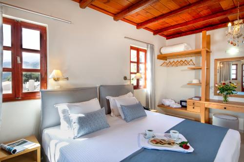 a bedroom with a bed with a tray of food on it at Stefanos Village Hotel in Plakias