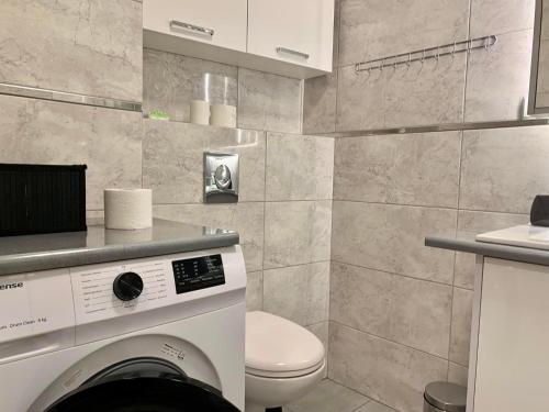 y baño con lavadora y aseo. en Apartamenty 5.0, en Wołomin