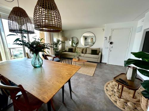 uma sala de estar com uma mesa e um sofá em SeaHomes Vacations - MARINA BOUTIQUE design em Santa Susanna