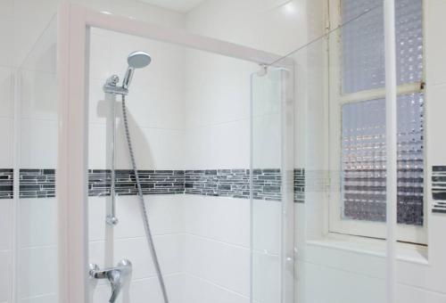 La salle de bains est pourvue d'une douche et d'une fenêtre. dans l'établissement Charmant appartement sur le vieux port, à Marseille