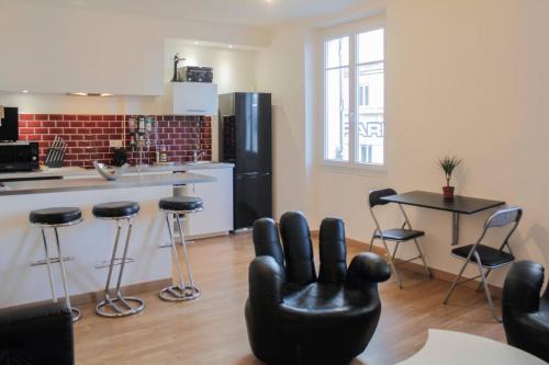 - un salon avec un fauteuil en cuir noir dans la cuisine dans l'établissement Charmant appartement sur le vieux port, à Marseille