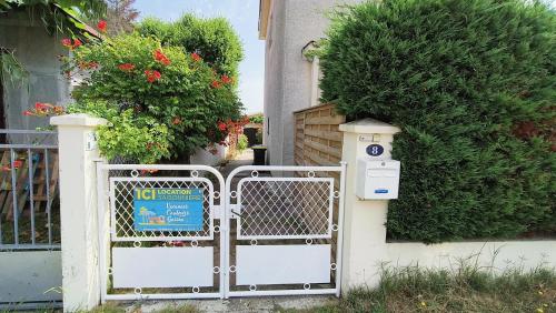 una puerta con un cartel delante de una casa en Charmante maison proche plage et centre, en Andernos-les-Bains
