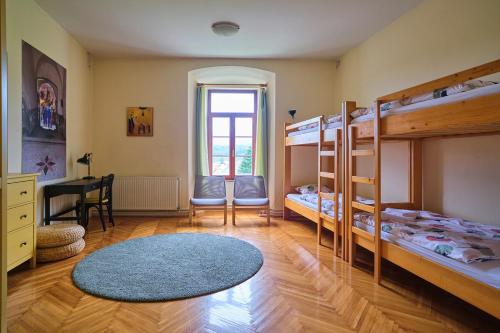 a room with three bunk beds and a desk at Samostan Mekinje in Kamnik