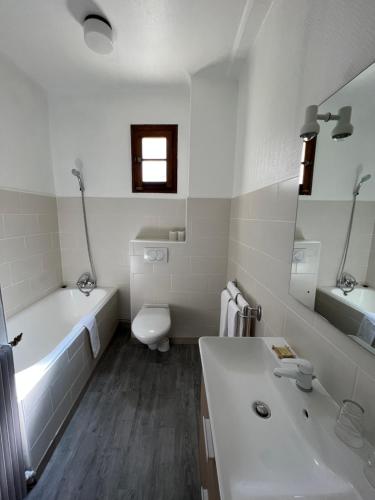 a bathroom with a tub and a toilet and a sink at Hôtel Le Coq d'Or in Les Angles