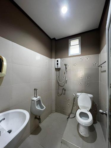 a bathroom with a toilet and a urinal and a sink at Gn story love บ้านเกาะล้าน 小珊瑚岛班泳池别墅 in Ko Larn