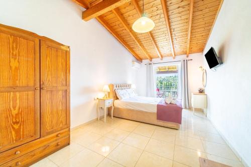 a bedroom with a bed and a large window at Arianna Deluxe Studio 20 in Paleokastritsa