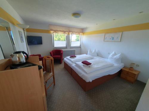 a hotel room with a bed and a chair at Feriendorf Fuchsberg in Schirgiswalde