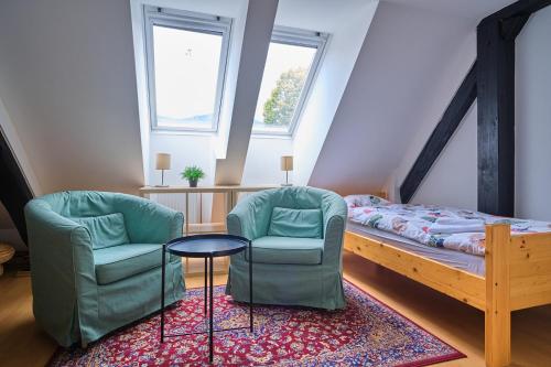 a room with two chairs and a bed and a table at Samostan Mekinje in Kamnik