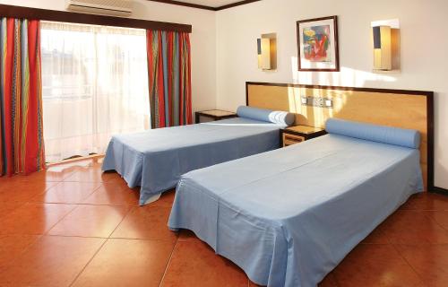 Habitación de hotel con 2 camas y ventana en Hotel Apartamento Paraiso De Albufeira, en Albufeira
