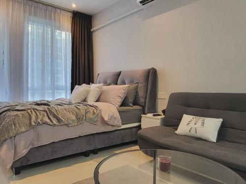 a bedroom with a bed and a couch and a glass table at [Instastellar Experience] 3 Pax, 15 mins fr CIQ in Johor Bahru