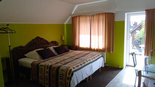 a bedroom with a bed with green walls and a window at Hotel Getliin in Saku