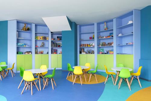 a classroom with tables and chairs and bookshelves at Alua Helios Bay - All Inclusive in Obzor