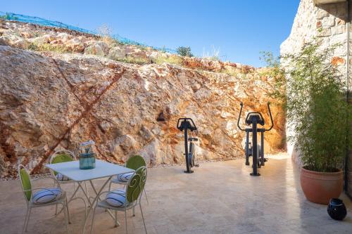 a patio with a table and chairs and a stone wall at Villa Nai 3.3 in Žman