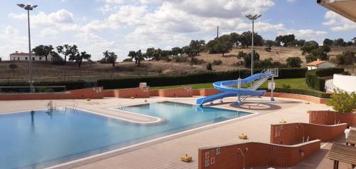 une grande piscine avec un toboggan au milieu dans l'établissement Casa das Rosas, à Crato