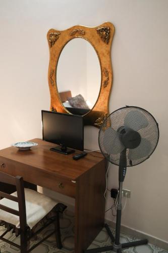 a desk with a computer and a mirror and a fan at Alle Antiche Mura in Caiazzo
