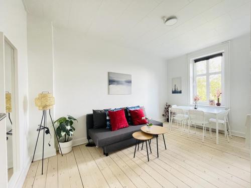 un soggiorno con divano e tavolo di aday - Ocean Shores central Apartment a Frederikshavn