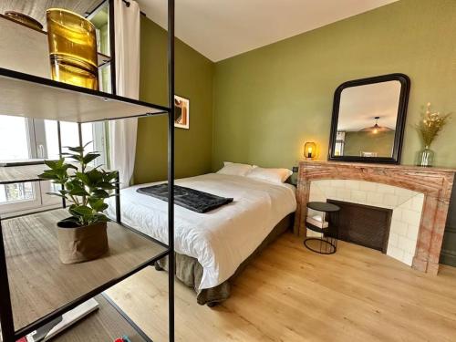 a bedroom with a bed with a fireplace and a mirror at Bel appart Bd Foch in Angers