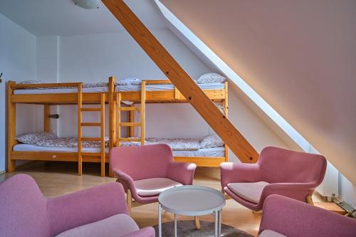 a room with two bunk beds and chairs and a table at Samostan Mekinje in Kamnik