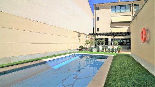 a swimming pool in front of a building at Hotel Ele Puente Romano de Salamanca in Salamanca