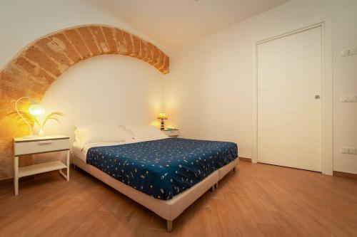 ein Schlafzimmer mit einem Bett und einer Ziegelwand in der Unterkunft Confortevole Open Space [Centro Storico] in Marsala