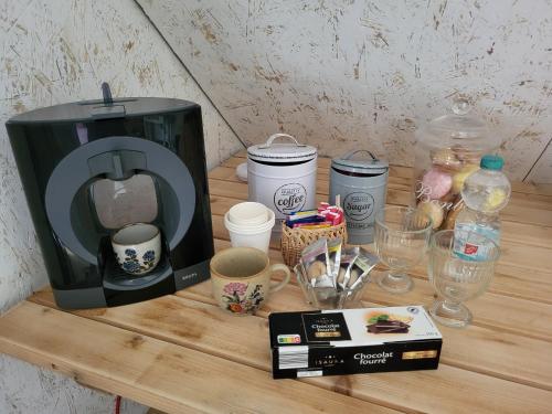 una mesa con cafetera y tazas. en La Kabane, en Fierville-les-Mines
