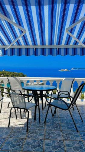 un tavolo e sedie su un patio con vista sull'oceano di Casa di Zanjic a Luštica (Lustizza)
