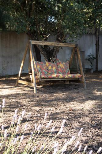 a swing bed in a yard with a tree at Aires da Serra Hotel in Torres Novas