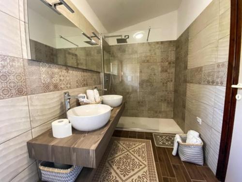 La salle de bains est pourvue d'un lavabo et d'un miroir. dans l'établissement B&B Peonia Sun light, à Capo Sperone