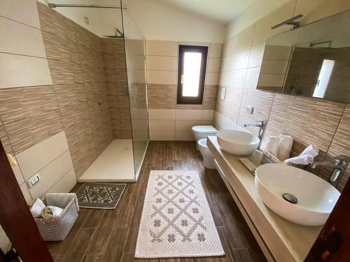 a bathroom with a sink and a shower and a toilet at B&B Peonia Sun light in SantʼAntìoco