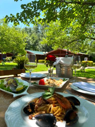 a table with plates of food and glasses of wine at Kompleksi Turistik Leonardo in Shëngjin
