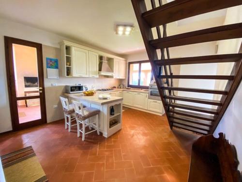 a kitchen with a table and a staircase in a house at B&B Peonia Sun light in SantʼAntìoco
