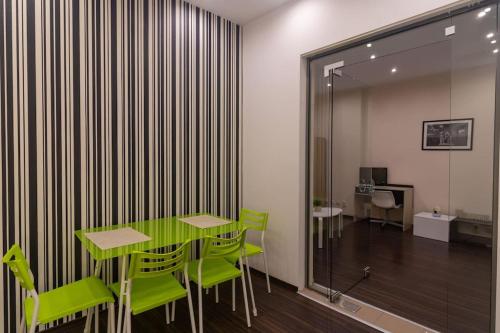 a dining room with a green table and green chairs at Ivo's 1 Bedroom Centrally Located Apartment in Sofia