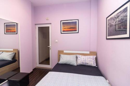 a small bedroom with a bed and pictures on the wall at Ivo's 1 Bedroom Centrally Located Apartment in Sofia