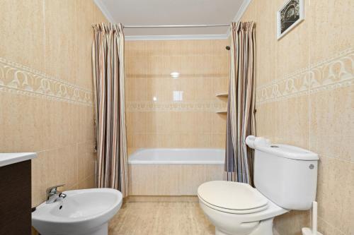 a bathroom with a toilet and a sink and a tub at Casa Marcin in Gran Alacant