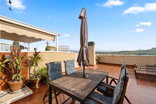 a patio table with an umbrella on a balcony at Casa Marcin in Gran Alacant