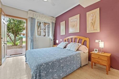 a bedroom with a bed with purple walls at Casa Marcin in Gran Alacant