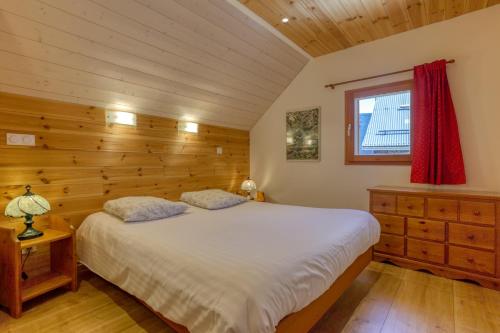 a bedroom with a white bed and a window at Chalet Ornon in Ornon