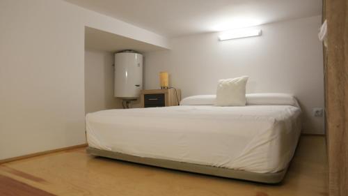 una camera da letto con un letto bianco e un cuscino sopra di Galileo apartment a Madrid