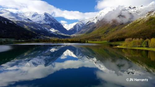 a reflection of the mountains in a lake at Accès direct aux pistes - appartement pour 4 in Génos