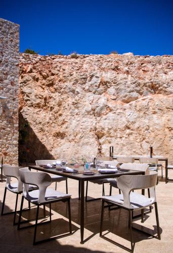 a table and chairs sitting in front of a stone wall at Villa Nai 3.3 in Žman
