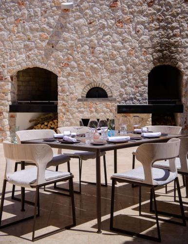 a wooden table and chairs in a room with a stone wall at Villa Nai 3.3 in Žman