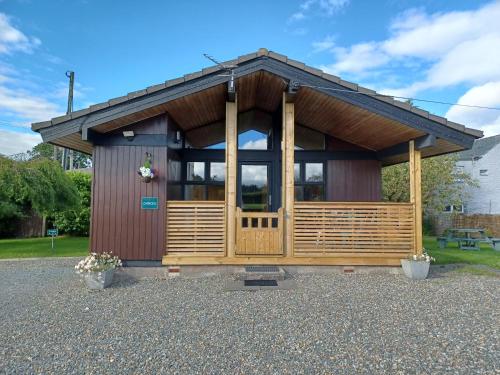a small cabin with a large door in a park at Green View Lodges in Wigton