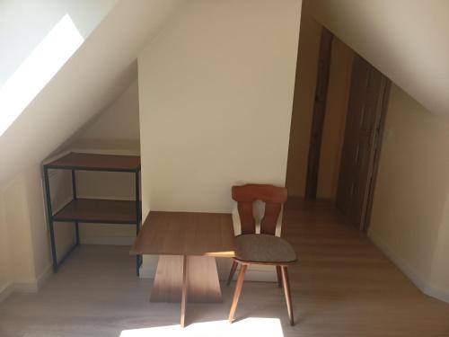 a wooden table and a chair in a room at Szewczenki 3 in Olsztyn